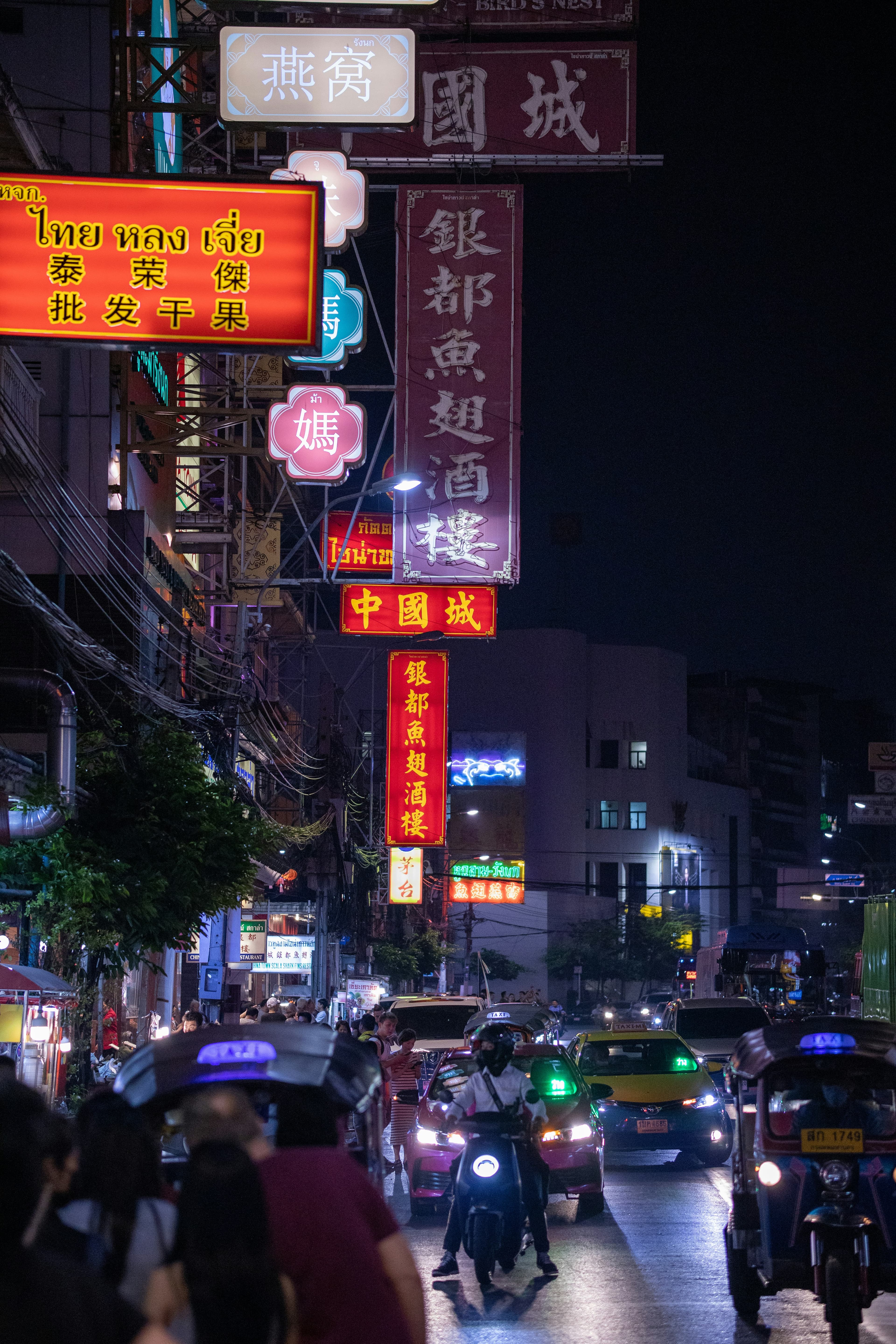 A neon-lit Asian street at night with motorbikes and Chinese signage